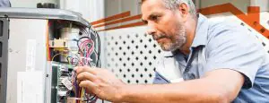 Man checking a broken heating unit.