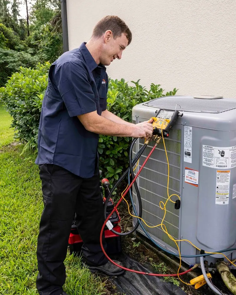 Strada Services technician working on HVAC system outside