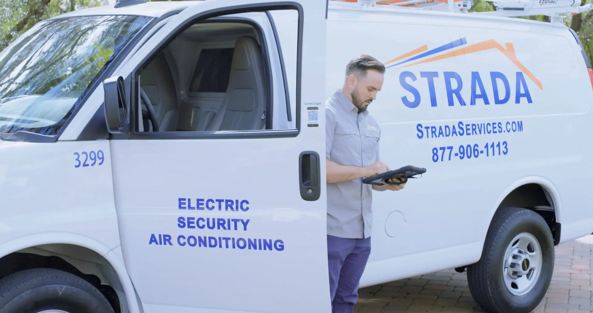 Strada Service technician standing outside service truck